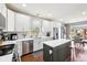 Bright kitchen with stainless steel appliances, white cabinets, an island and hardwood flooring at 12404 Guy Way, Indianapolis, IN 46236