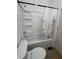 Bathroom with a white shower and tub, toilet, and light brown floors at 1256 Kappes St, Indianapolis, IN 46221