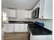 Kitchen featuring white cabinets, modern appliances, and black countertops at 1256 Kappes St, Indianapolis, IN 46221