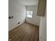 Bright, open room with wood-look floors, white walls, and window at 1256 Kappes St, Indianapolis, IN 46221