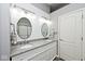 Bathroom boasts a double sink vanity with granite countertops, shiplap walls, and stylish oval mirrors at 1311 Flintlock Dr, Greenwood, IN 46143