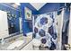 Vibrant blue bathroom features a vanity, toilet, and shower with a stylish geometric shower curtain at 1311 Flintlock Dr, Greenwood, IN 46143