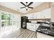 Bright kitchen features white cabinetry, black appliances, black marble countertops, and a sliding glass door to deck at 1311 Flintlock Dr, Greenwood, IN 46143