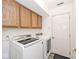 Well-lit laundry room features a washer and dryer, and ample overhead cabinet storage at 1311 Flintlock Dr, Greenwood, IN 46143