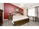Warm and inviting main bedroom features a large bed, red accent wall, and neutral carpet at 1311 Flintlock Dr, Greenwood, IN 46143