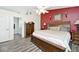 Spacious main bedroom features a red accent wall, king bed, and access to ensuite bathroom at 1311 Flintlock Dr, Greenwood, IN 46143