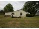 Exterior shot showcasing the home's side profile, set on a grassy lot with mature trees at 1325 N Gavin St, Muncie, IN 47303