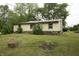 Cozy home with stone accents at the base, set amidst mature trees and a spacious yard at 1325 N Gavin St, Muncie, IN 47303