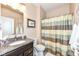 Bathroom featuring granite counters, vanity with sink, and shower with neutral striped curtain at 13427 Merryvale St, Fishers, IN 46037