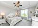 Relaxing bedroom features a ceiling fan, tray ceiling, and large windows with natural light at 13427 Merryvale St, Fishers, IN 46037