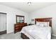 Cozy bedroom with classic wood furniture, soft carpeting, and comfortable patchwork bedding at 13427 Merryvale St, Fishers, IN 46037