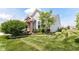 Landscaped front yard showing a brick entryway, mature tree and manicured green lawn at 13427 Merryvale St, Fishers, IN 46037