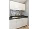 Practical laundry area features stylish backsplash, granite counter and efficient storage at 13427 Merryvale St, Fishers, IN 46037