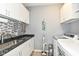 Functional laundry room features modern appliances, ample cabinetry and mosaic backsplash at 13427 Merryvale St, Fishers, IN 46037
