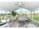 Bright sunroom features a ceiling fan, large windows, and stylish furnishings overlooking the backyard at 13427 Merryvale St, Fishers, IN 46037
