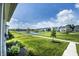 Scenic backyard view featuring a serene pond, lush green space, and charming neighborhood homes at 14404 Stairbridge Pl, Carmel, IN 46074