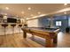 Entertaining basement space featuring a pool table, wet bar with seating, and access to the media room at 14404 Stairbridge Pl, Carmel, IN 46074