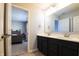 This bathroom features a double vanity with black cabinets, white countertop and view to the second bedroom at 14404 Stairbridge Pl, Carmel, IN 46074