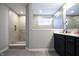 Modern bathroom with a tiled walk-in shower, vanity with black cabinets, and tile flooring at 14404 Stairbridge Pl, Carmel, IN 46074