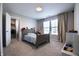 This bedroom features a wooden bed frame and a walk-in closet with open white door and a window with blinds at 14404 Stairbridge Pl, Carmel, IN 46074