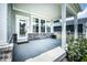 Covered porch featuring vinyl siding, brick base, windows, a glass paneled door, and concrete flooring at 14404 Stairbridge Pl, Carmel, IN 46074