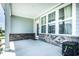 Covered porch featuring vinyl siding, brick base, windows, a glass paneled door, and concrete flooring at 14404 Stairbridge Pl, Carmel, IN 46074