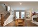 Open dining area with a wooden table, staircase, and views of the fireplace in the living room at 14404 Stairbridge Pl, Carmel, IN 46074