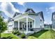 Side angle of the home featuring a cozy covered side porch with brickwork, and a well maintained lawn at 14404 Stairbridge Pl, Carmel, IN 46074