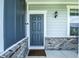 Elegant front entrance featuring a blue door with white trim, a classic lantern, and beautiful brick accents at 14404 Stairbridge Pl, Carmel, IN 46074