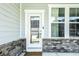 Close up of the glass paneled front door with brickwork, vinyl siding, and a window at 14404 Stairbridge Pl, Carmel, IN 46074