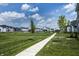 Expansive green space in a residential neighborhood with manicured lawns and sidewalks at 14404 Stairbridge Pl, Carmel, IN 46074