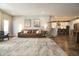 Open concept living room featuring a leather sofa, a hanging chair and view into the kitchen at 14404 Stairbridge Pl, Carmel, IN 46074