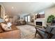 Open-concept living room featuring recessed lighting, hardwood floors, a cozy fireplace, and comfortable seating at 14404 Stairbridge Pl, Carmel, IN 46074