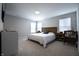 Comfortable main bedroom featuring neutral decor, a wooden bed frame, and a ceiling fan at 14404 Stairbridge Pl, Carmel, IN 46074