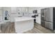 Modern kitchen with white cabinetry, stainless steel appliances, an island and wood-style flooring at 14514 Hanford Ln, Carmel, IN 46074