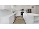 Modern kitchen with white cabinetry, stainless steel appliances, an island and wood-style flooring at 14514 Hanford Ln, Carmel, IN 46074