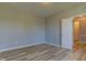 Clean, empty bedroom with light gray walls, light wood floors, and a white door at 14620 Hinton Dr, Fishers, IN 46037