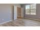 Empty bedroom features light wood floors, double doors, a window, and neutral colored walls at 14620 Hinton Dr, Fishers, IN 46037