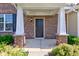 Welcoming front porch with brick pillars, a dark front door, and green bushes creating curb appeal at 14620 Hinton Dr, Fishers, IN 46037