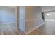 Neutral hallway with wainscoting, light wood floors, and doors to other rooms at 14620 Hinton Dr, Fishers, IN 46037