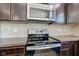 Modern kitchen range with stainless steel appliances, backsplash, and sleek black cooktop at 14620 Hinton Dr, Fishers, IN 46037