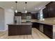 Well-lit kitchen features stainless steel appliances, dark cabinets, granite countertops, and a large center island at 14620 Hinton Dr, Fishers, IN 46037