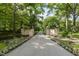 Long driveway to gated entrance with stone pillars and manicured flowerbeds at 1616 W 116Th St, Carmel, IN 46032