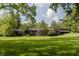 View of the home's exterior featuring manicured lawns and mature shade trees at 1616 W 116Th St, Carmel, IN 46032