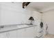 Laundry room with gray countertop, white cabinetry, and a modern washer and dryer at 1616 W 116Th St, Carmel, IN 46032