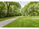 Sprawling lush green yard with mature trees and a paved walkway at 1616 W 116Th St, Carmel, IN 46032