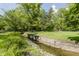 Scenic view of the yard with a creek and lush landscaping at 1616 W 116Th St, Carmel, IN 46032
