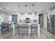 Modern open kitchen boasts stainless steel appliances, gray-toned floors, and a central island with barstools at 18980 Seaforth Way, Westfield, IN 46074
