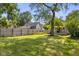 A large shade tree and wooden fence enhance this expansive green backyard at 1927 N Cherry St, Columbus, IN 47201