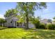 A grassy backyard features an old shed and a nice shade tree at 1927 N Cherry St, Columbus, IN 47201